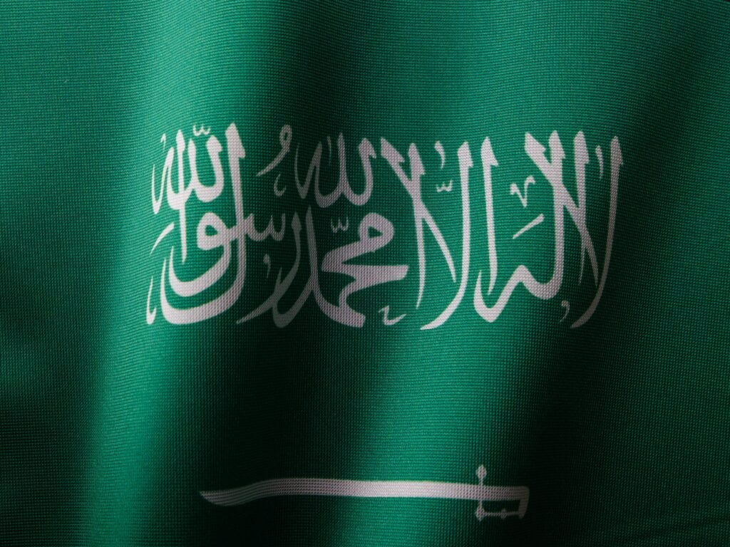 Detailed close-up of the Saudi Arabian flag showcasing the elegant Arabic script and vibrant green color.