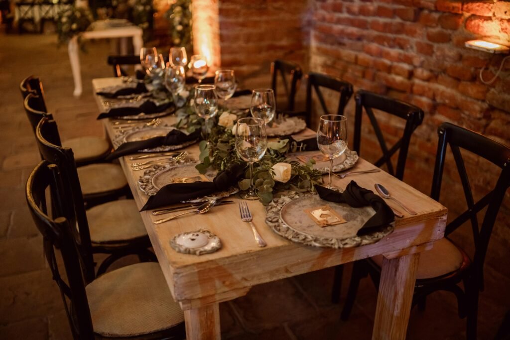 المبادئ الأساسية لتصميم الطاولات للضيافة؟ 5 A beautifully decorated rustic wedding table with elegant tableware and floral decor.